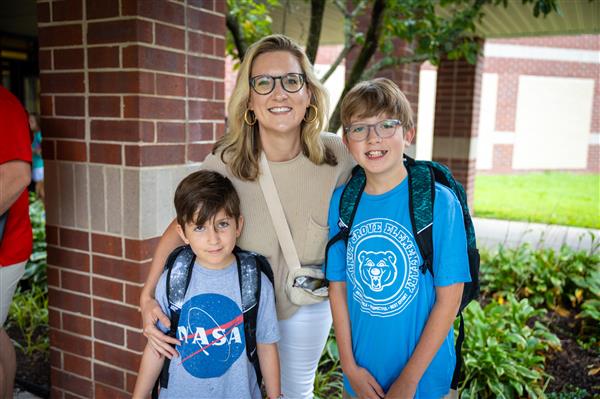 mom with two boy students in blue shirts